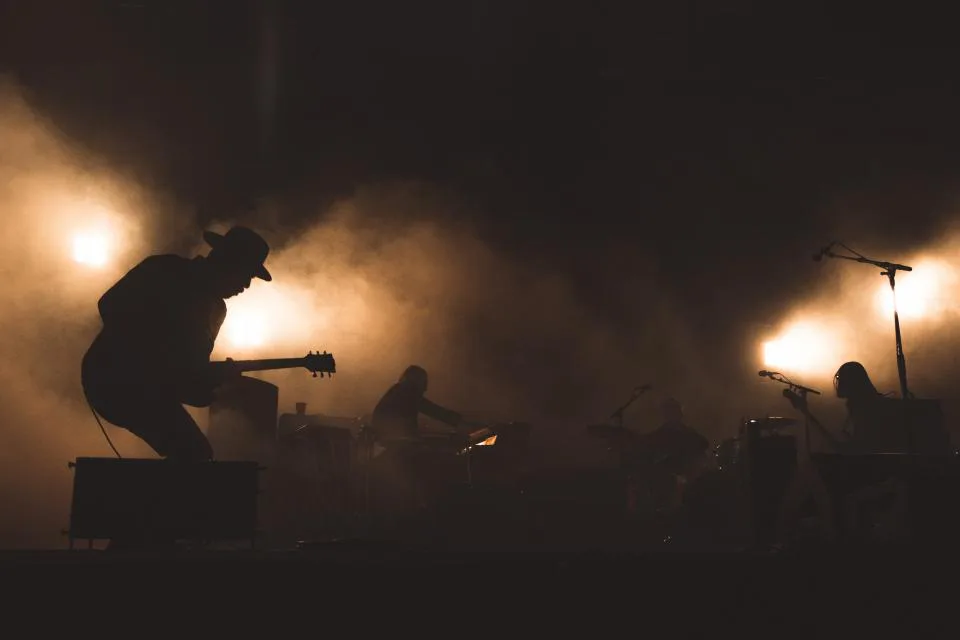 Silhouette of a musician performing on a concert stage