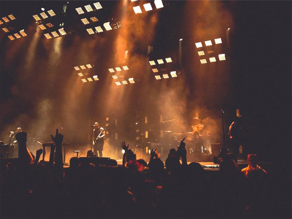 Concert stage bathed in dramatic lights during a live performance
