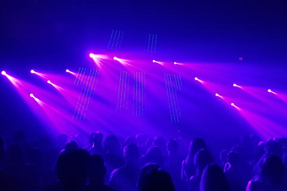 Purple stage lights sweeping over a crowd at a live show