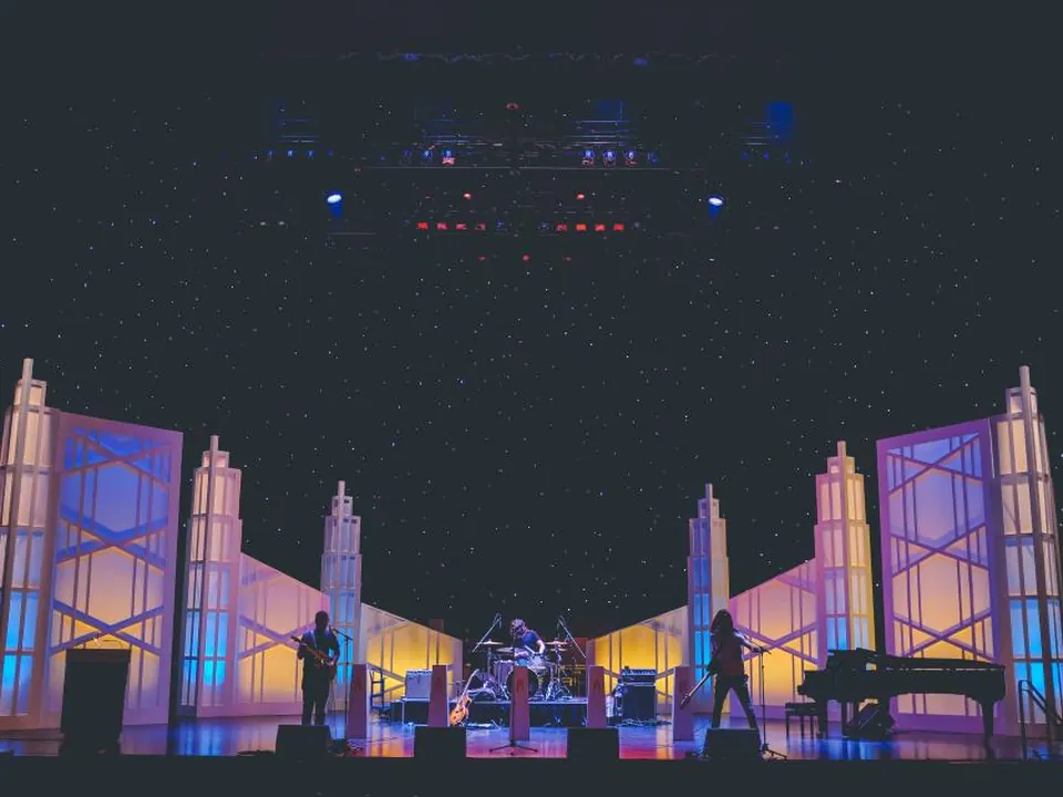 Glamorous theatrical stage with art deco skyline set pieces under a starry backdrop