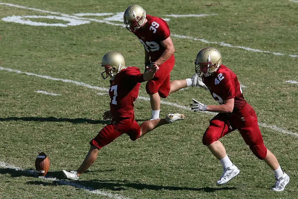 Football players in action at the moment of a kickoff