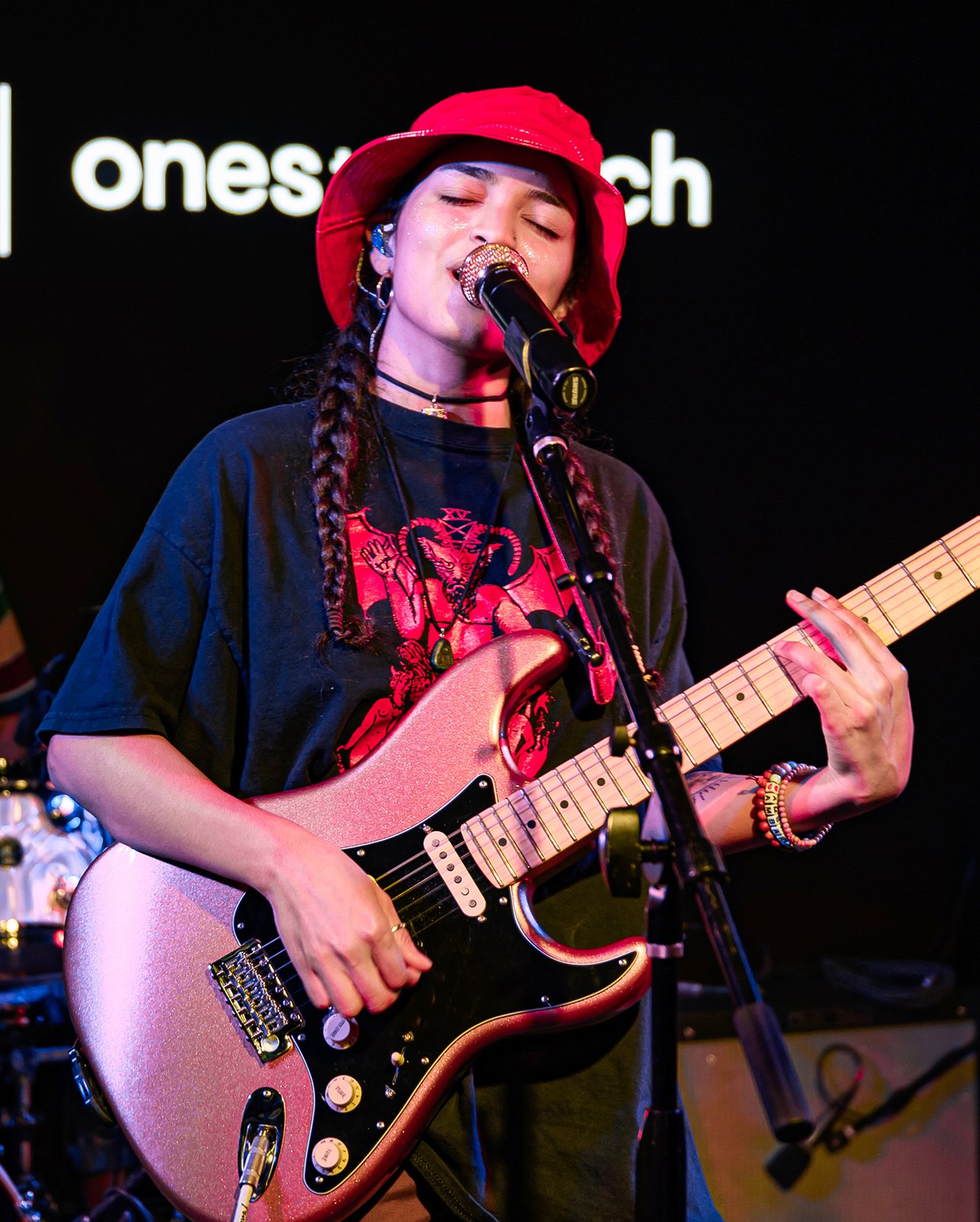 Ambar Lucid singing and playing guitar at a Live Nation showcase in Los Angeles, 2019