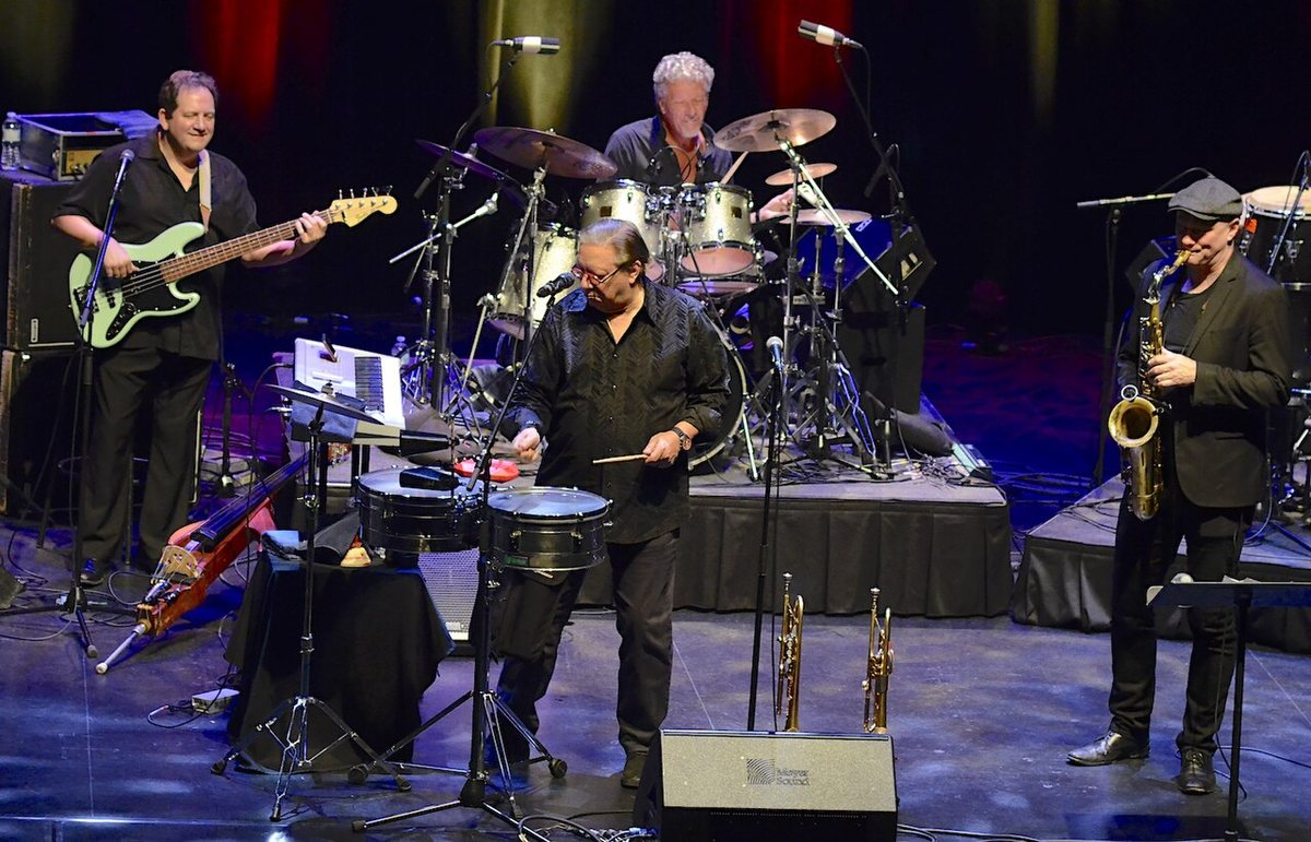 Arturo Sandoval playing timbales with his band on stage, 2019