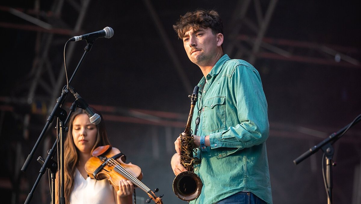 Buy Black Country, New Road tickets on StubOrder Black Country, New Road saxophonist and violinist on stage at Wide Awake Festival, Brockwell Park, London, 2021