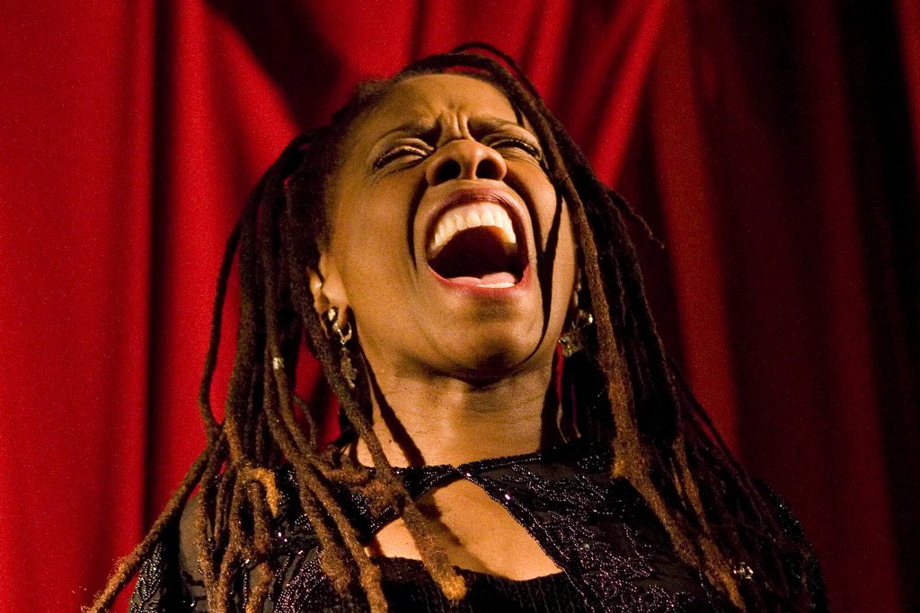 Catherine Russell singing in concert in front of a red curtain, 2009