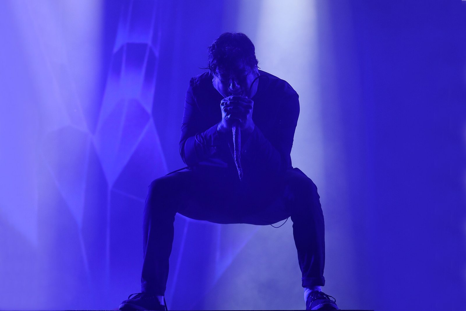 Chino Moreno of Deftones crouching with the microphone at Rock im Park, Nuremberg, 2022