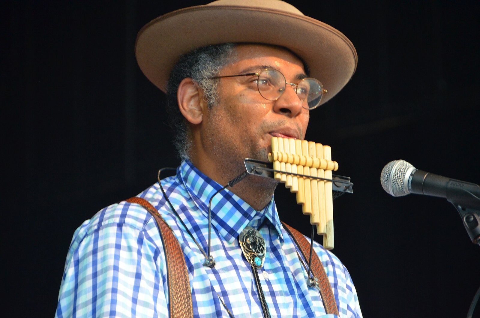 Dom Flemons playing panpipes on stage at the Philadelphia Folk Festival, 2019
