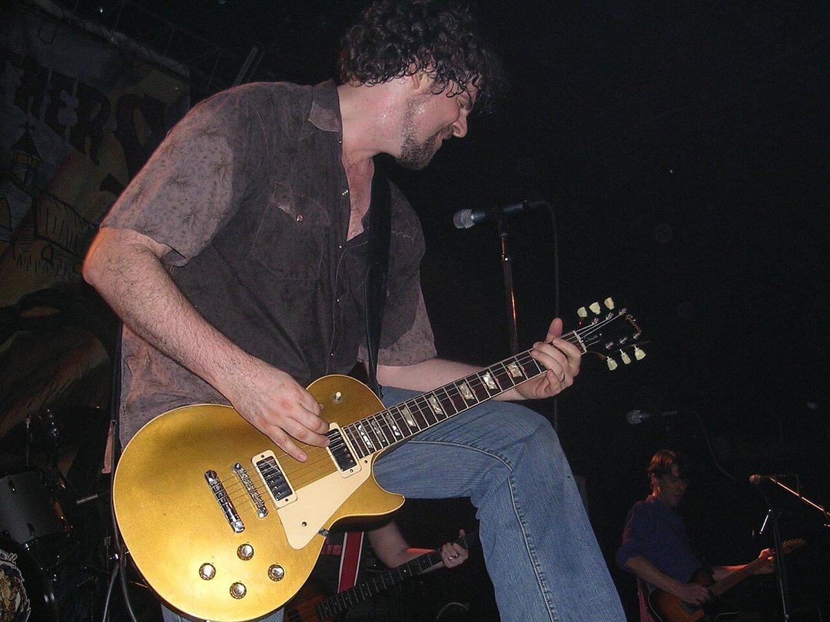 Buy Drive By Truckers tickets on StubOrder Patterson Hood of Drive-By Truckers playing a gold electric guitar on stage