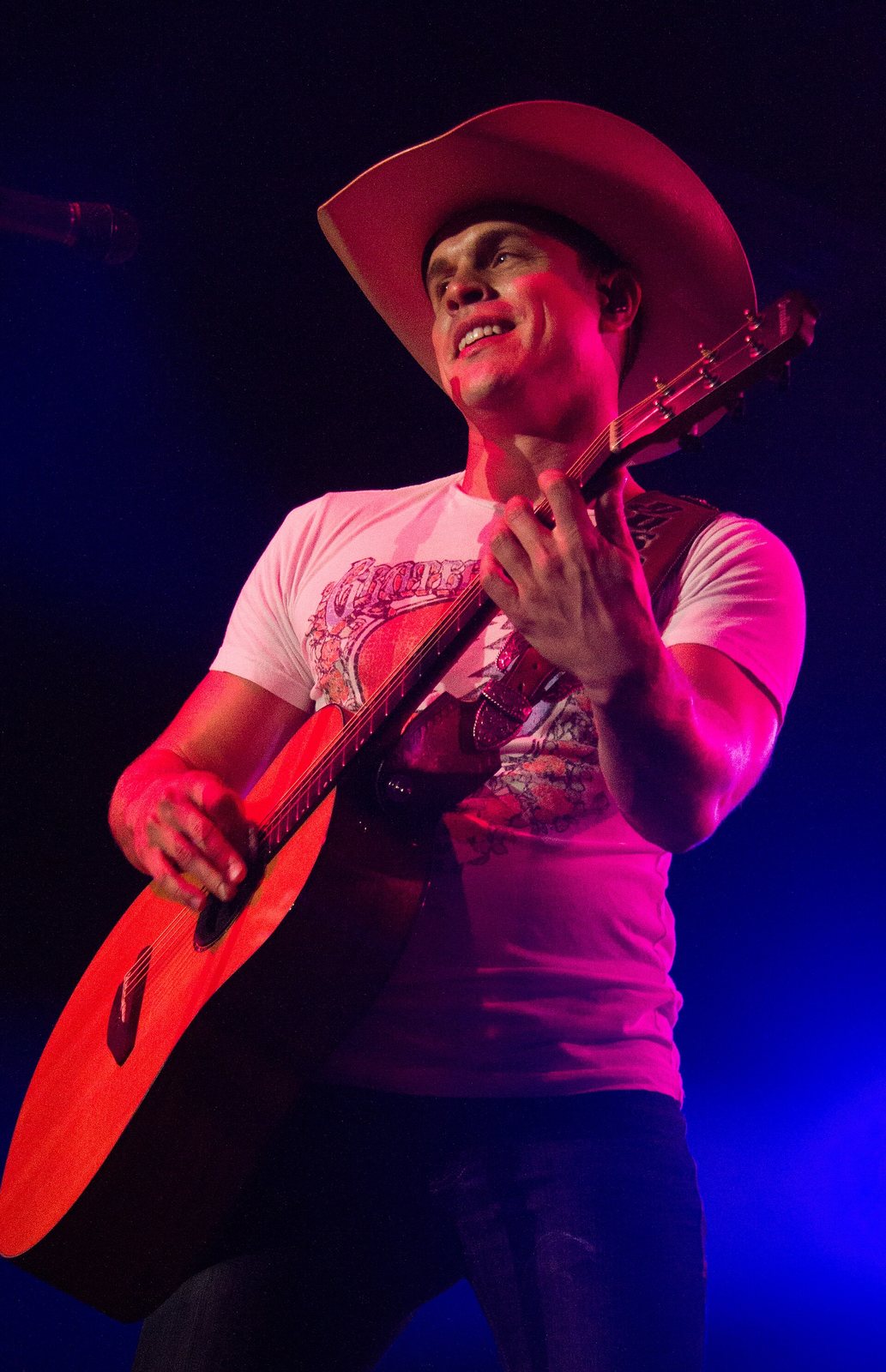 Dustin Lynch playing acoustic guitar in concert in Iowa, 2015