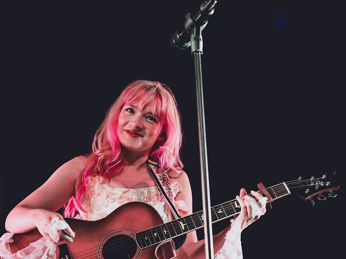 Ella Red playing acoustic guitar on stage at the Constellation Room, August 2026