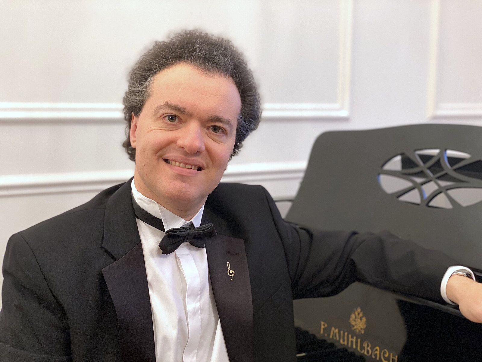 Pianist Evgeny Kissin in concert dress seated at a grand piano, 2021