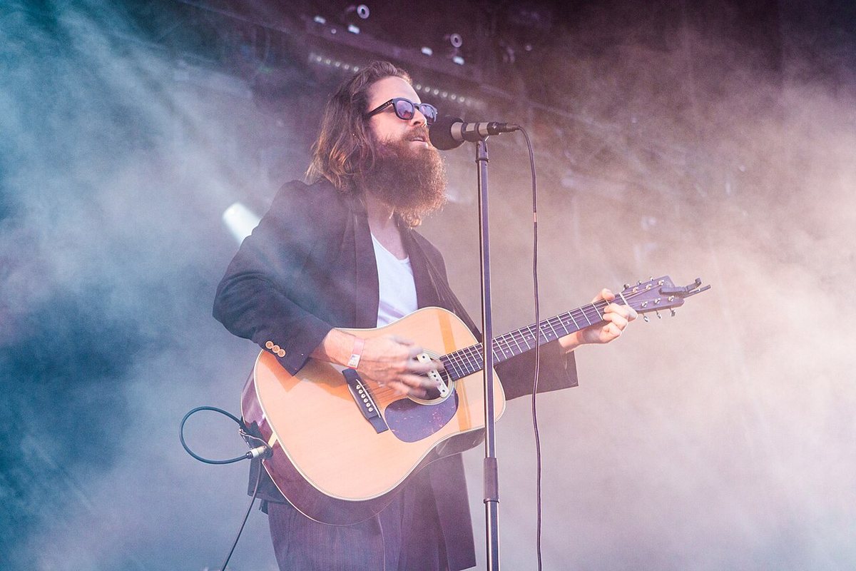 Father John Misty playing acoustic guitar in stage haze at Haldern Pop Festival, Germany, 2019