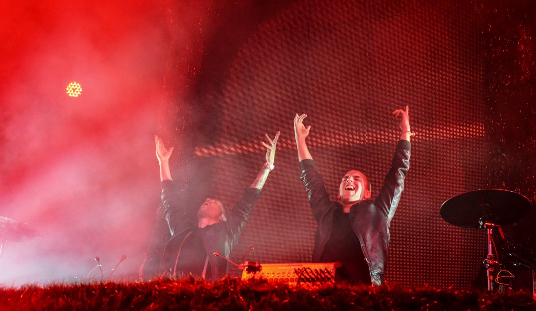 Galantis performing with arms raised under red stage lights at Coachella, April 2014