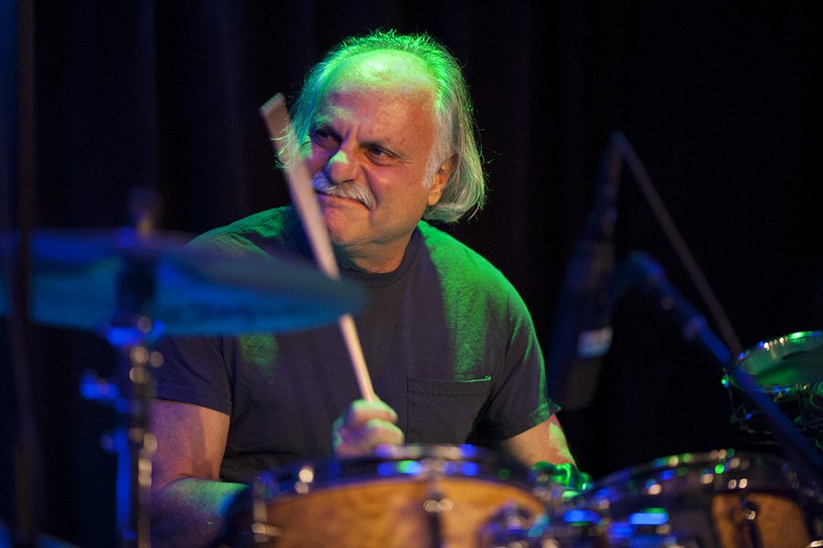 Greg Anton playing drums on stage, 2014