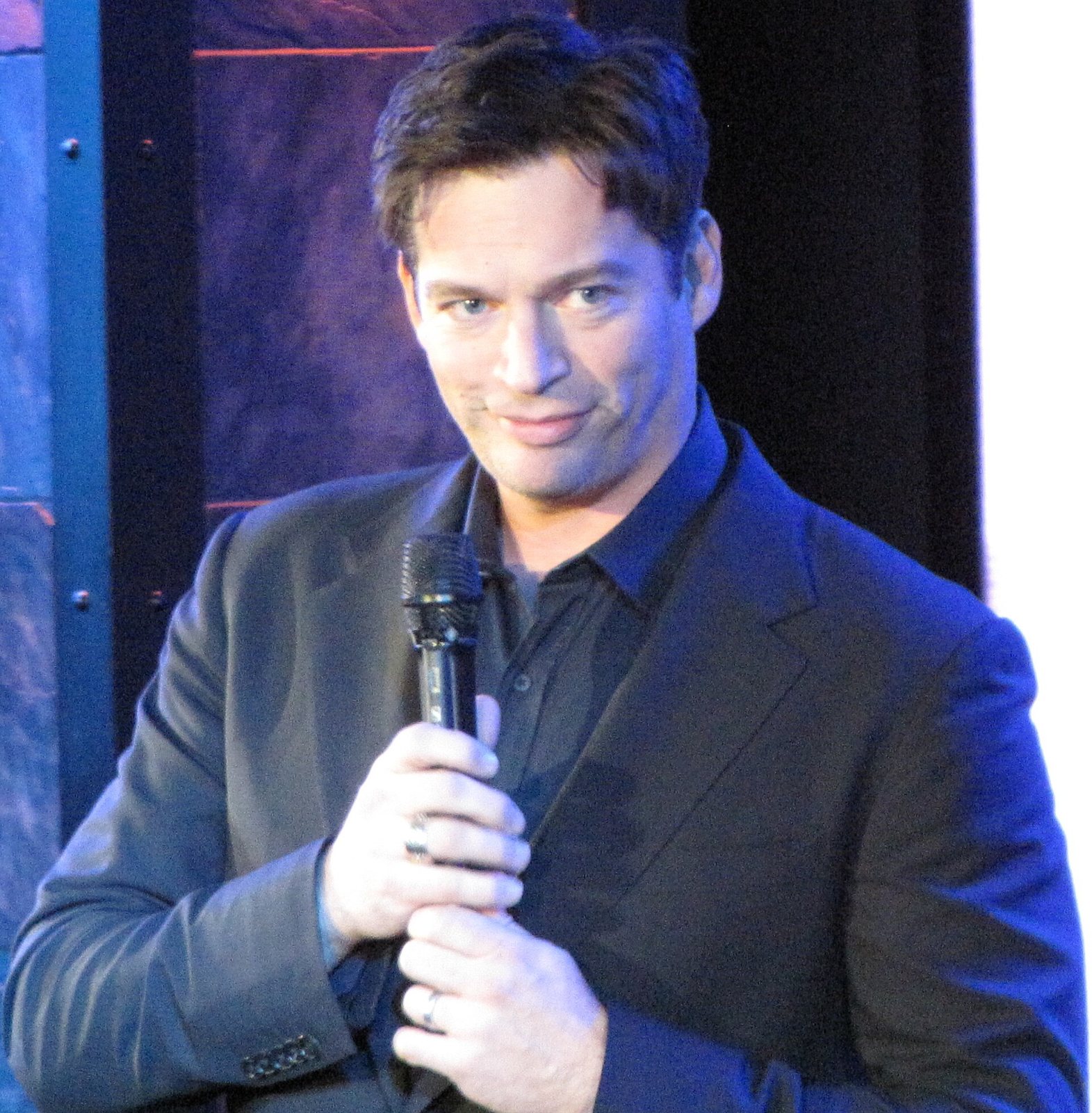 Harry Connick Jr. holding a microphone on stage at Blissdom, 2010