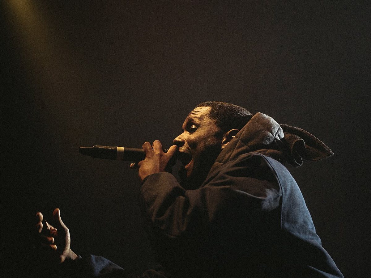 Jay Electronica performing on stage under a spotlight, 2018
