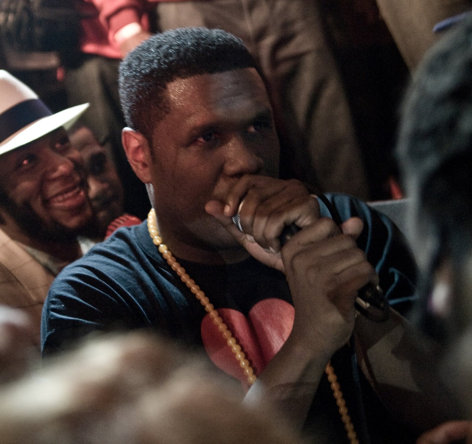 Jay Electronica rapping into a microphone surrounded by fans, 2010