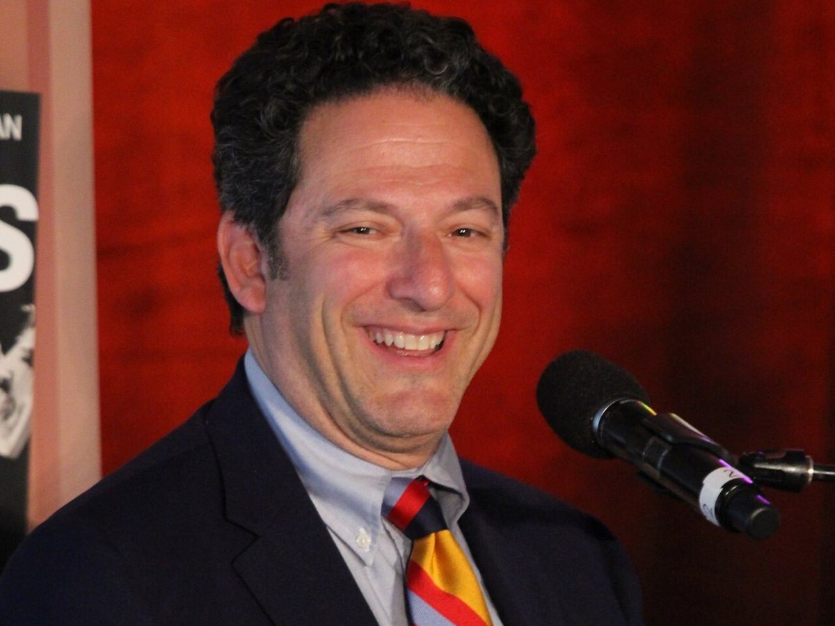 John Pizzarelli seated on stage at a microphone, smiling, 2014