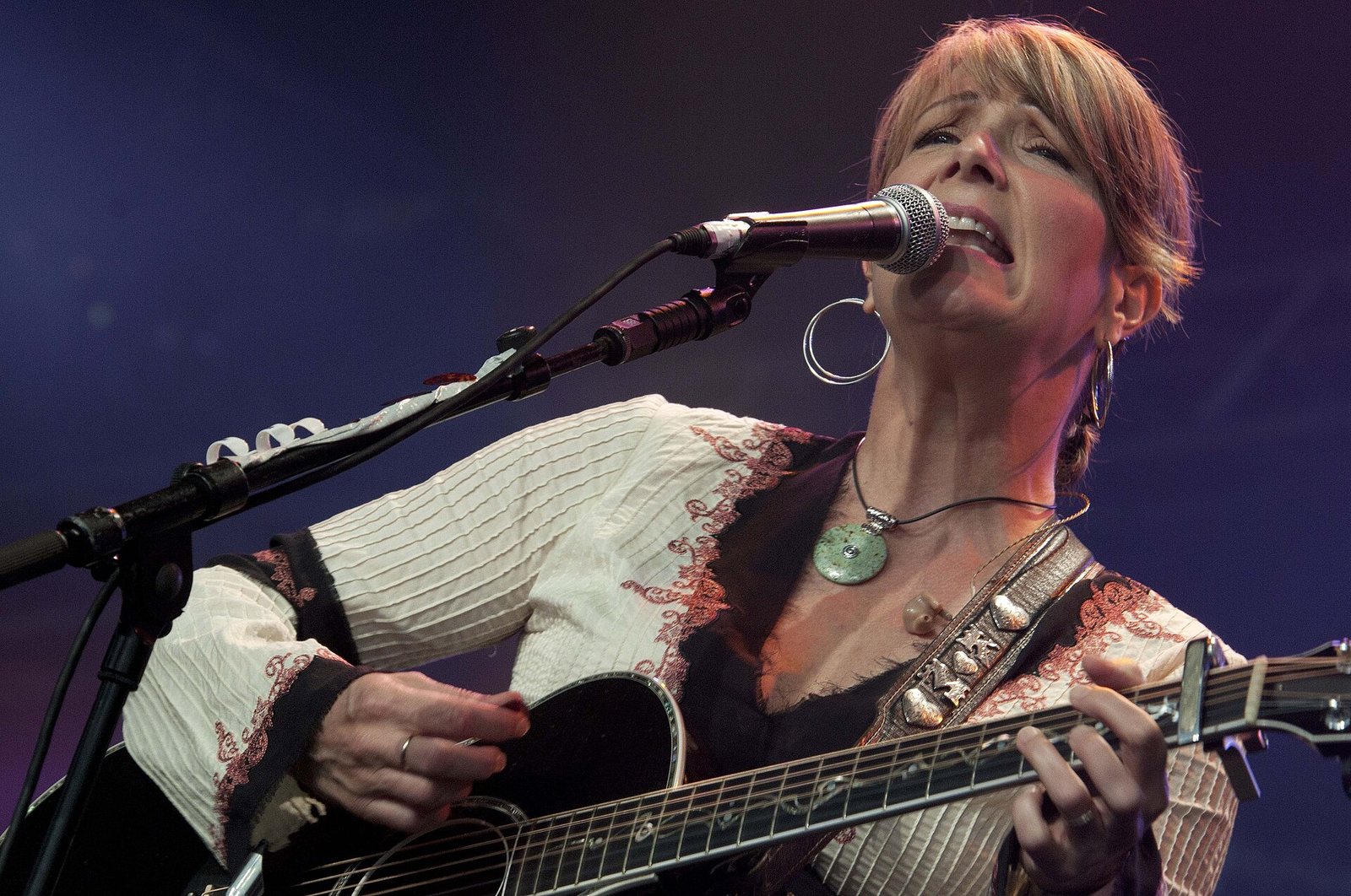 Kathy Mattea singing with an acoustic guitar at Cambridge Folk Festival, 2010