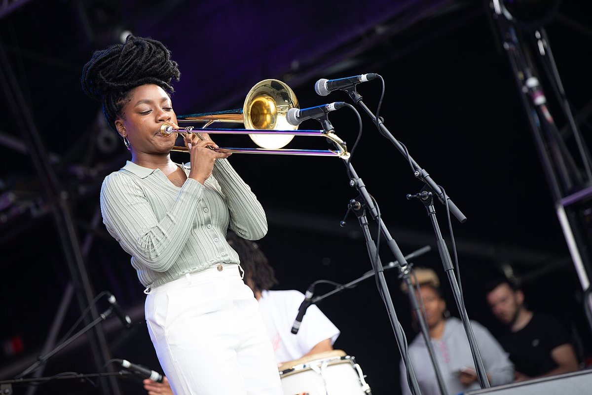 Kokoroko's trombonist playing on the West Holts stage at Glastonbury Festival, 2019, with percussion behind