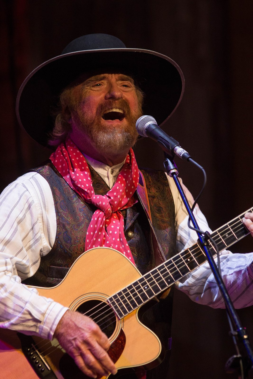 Michael Martin Murphey singing and playing acoustic guitar on stage, August 2017