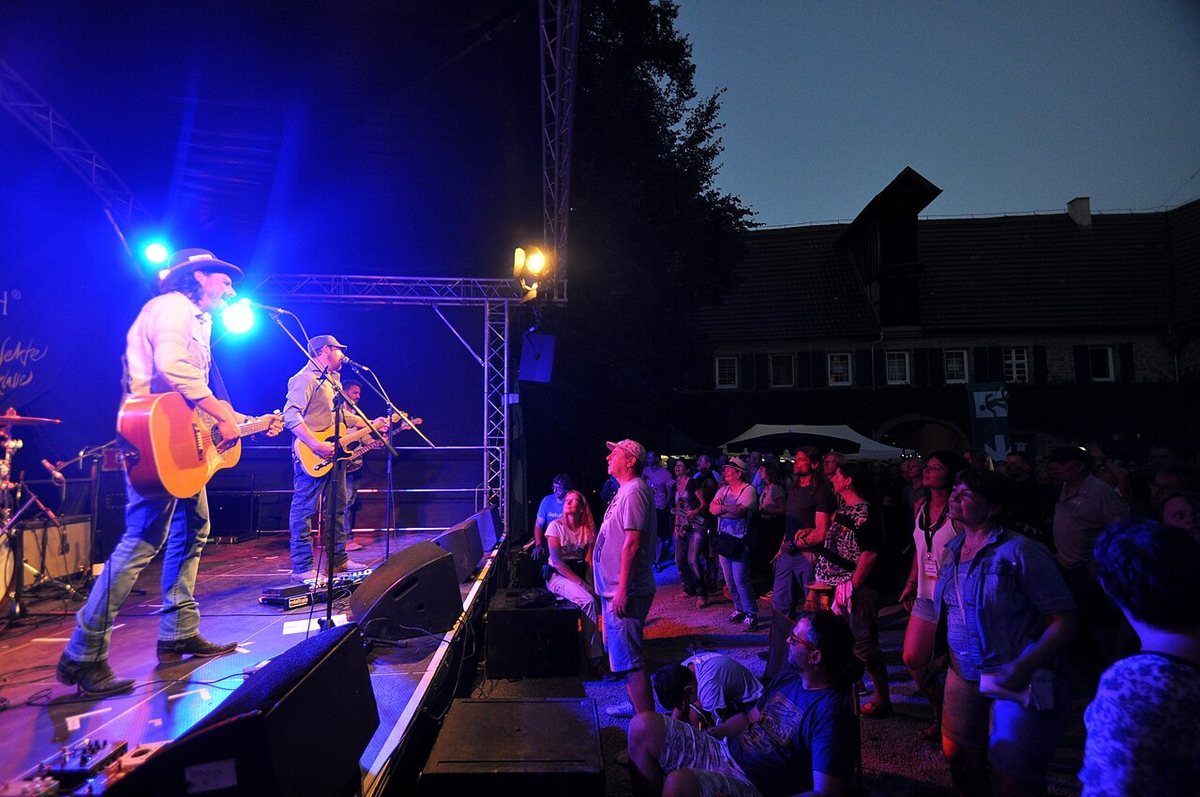 Micky and the Motorcars playing to an evening crowd at Blacksheep Festival, Germany, 2017