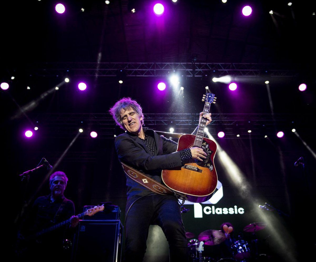 Mikel Erentxun playing acoustic guitar on stage in Plaza Mayor, Madrid, during San Isidro 2019