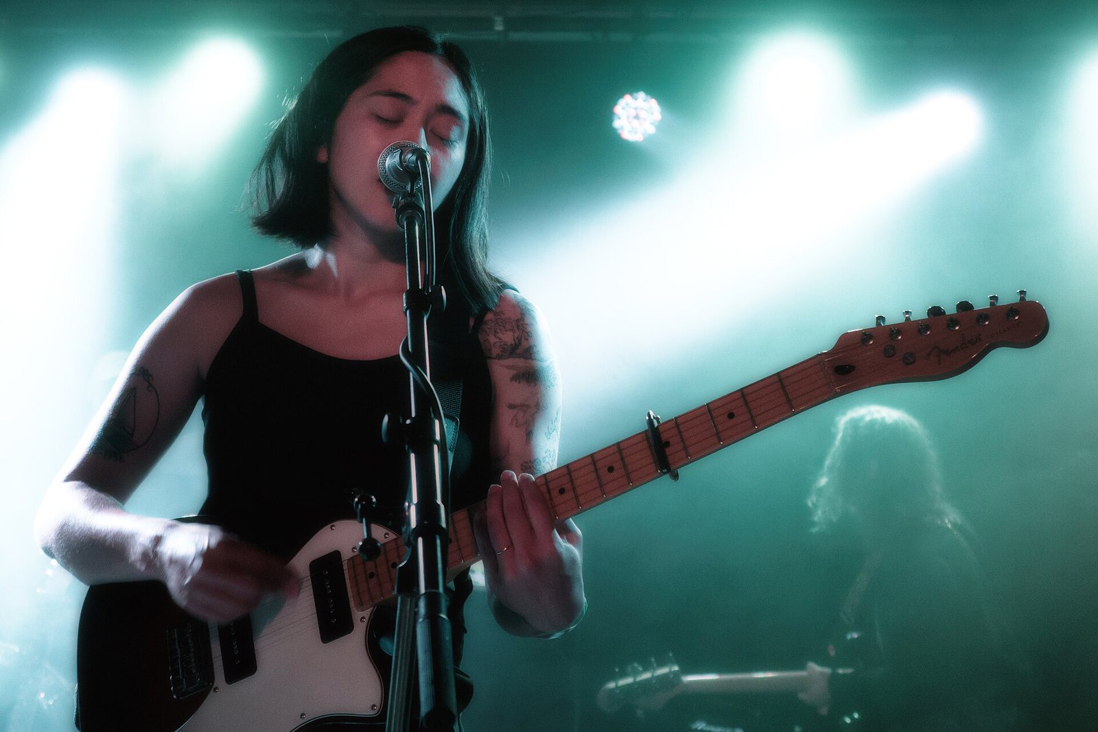 Mini Trees singing and playing guitar on stage at Madame Lou's, Seattle, June 2022