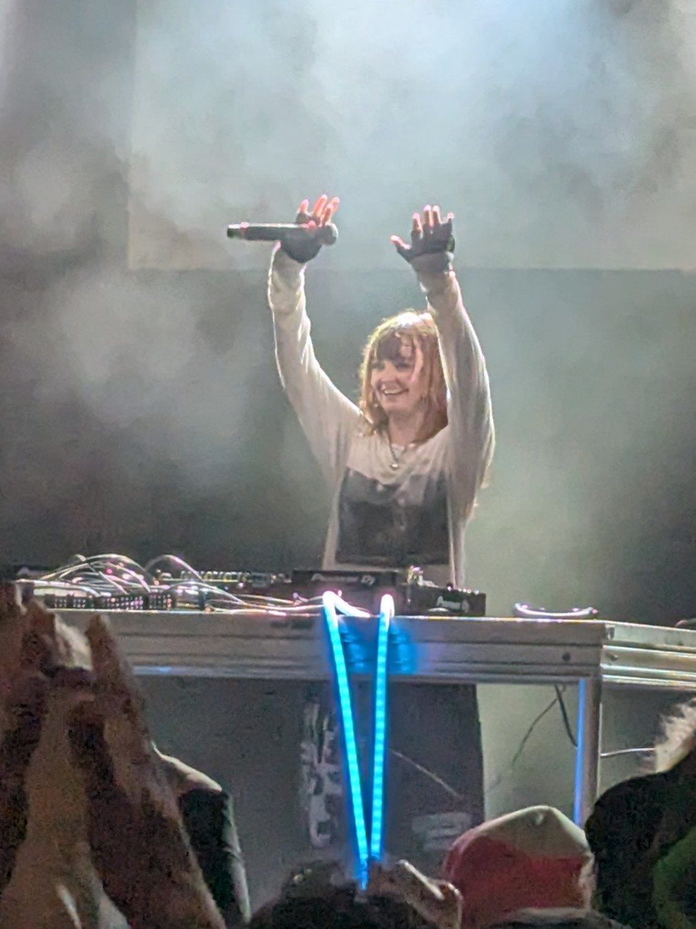 Ninajirachi raising her arms behind the DJ decks during a concert in Fort Collins, Colorado, January 2026