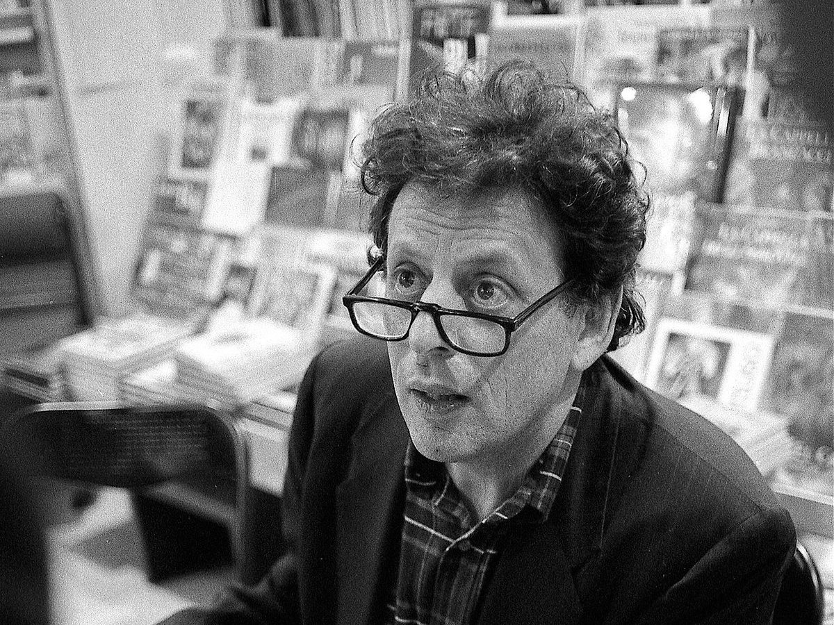 Philip Glass seated in a bookshop in Florence, Italy, 1993