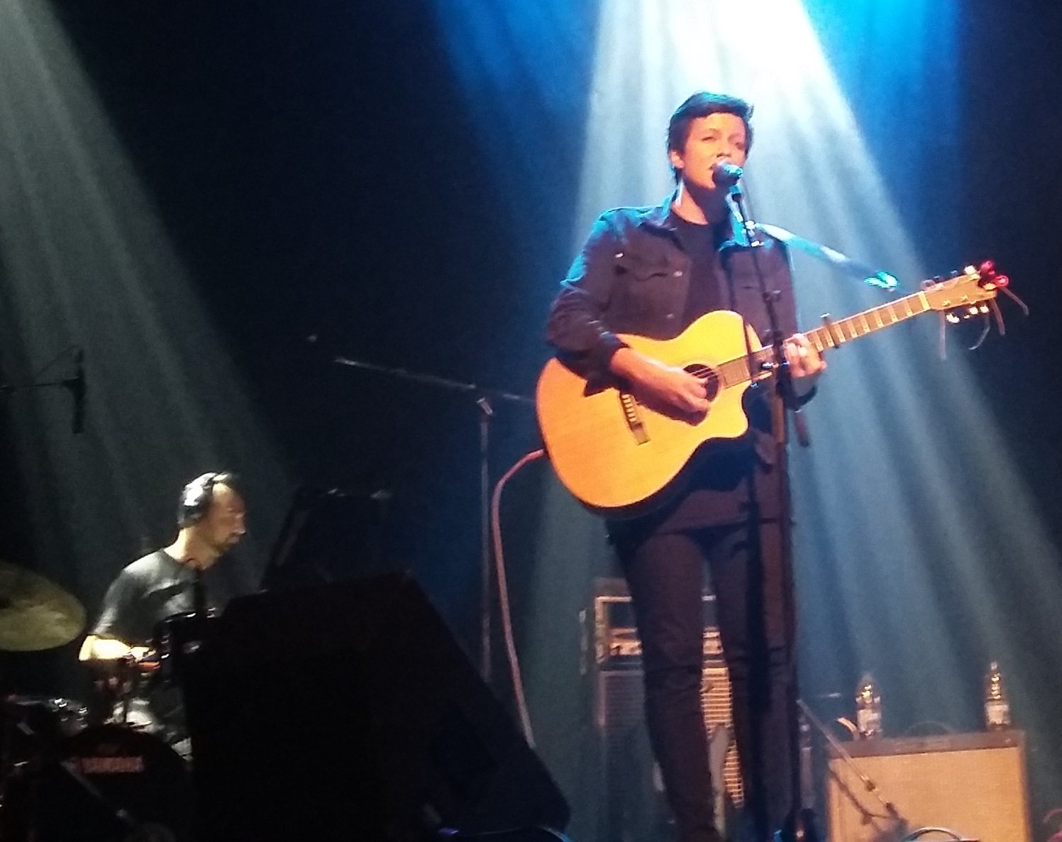 Ria Mae singing with an acoustic guitar on stage at Café Campus, Montreal, 2015