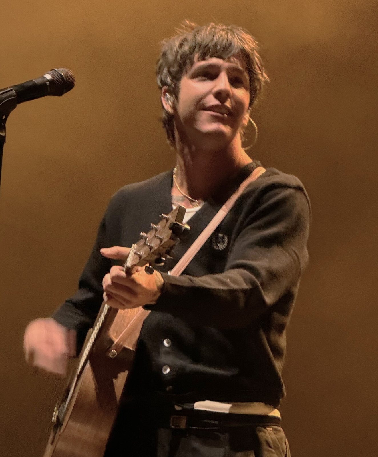 Role Model (Tucker Pillsbury) on stage with an acoustic guitar, 2024