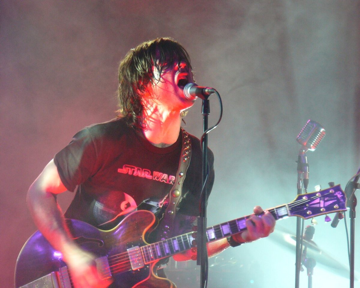 Ryan Adams singing and playing guitar on stage, 2006