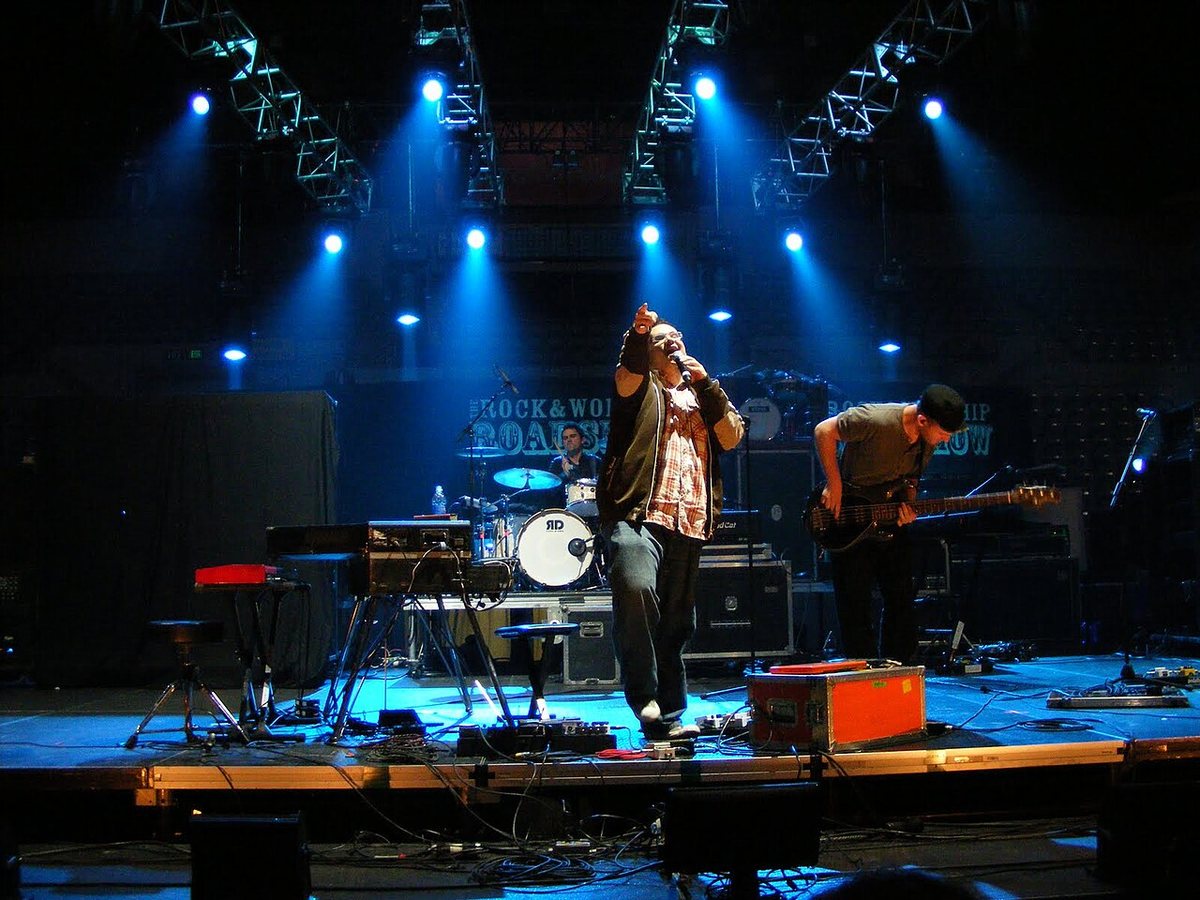 Sidewalk Prophets in concert, the singer at the front of the stage under blue spotlights