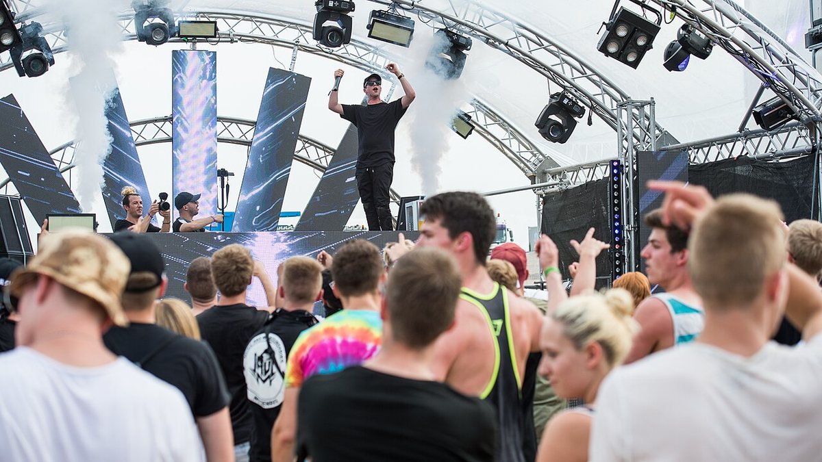 Slander on stage above the crowd, one member standing on the DJ booth, at Open Beatz festival, Germany, 2016