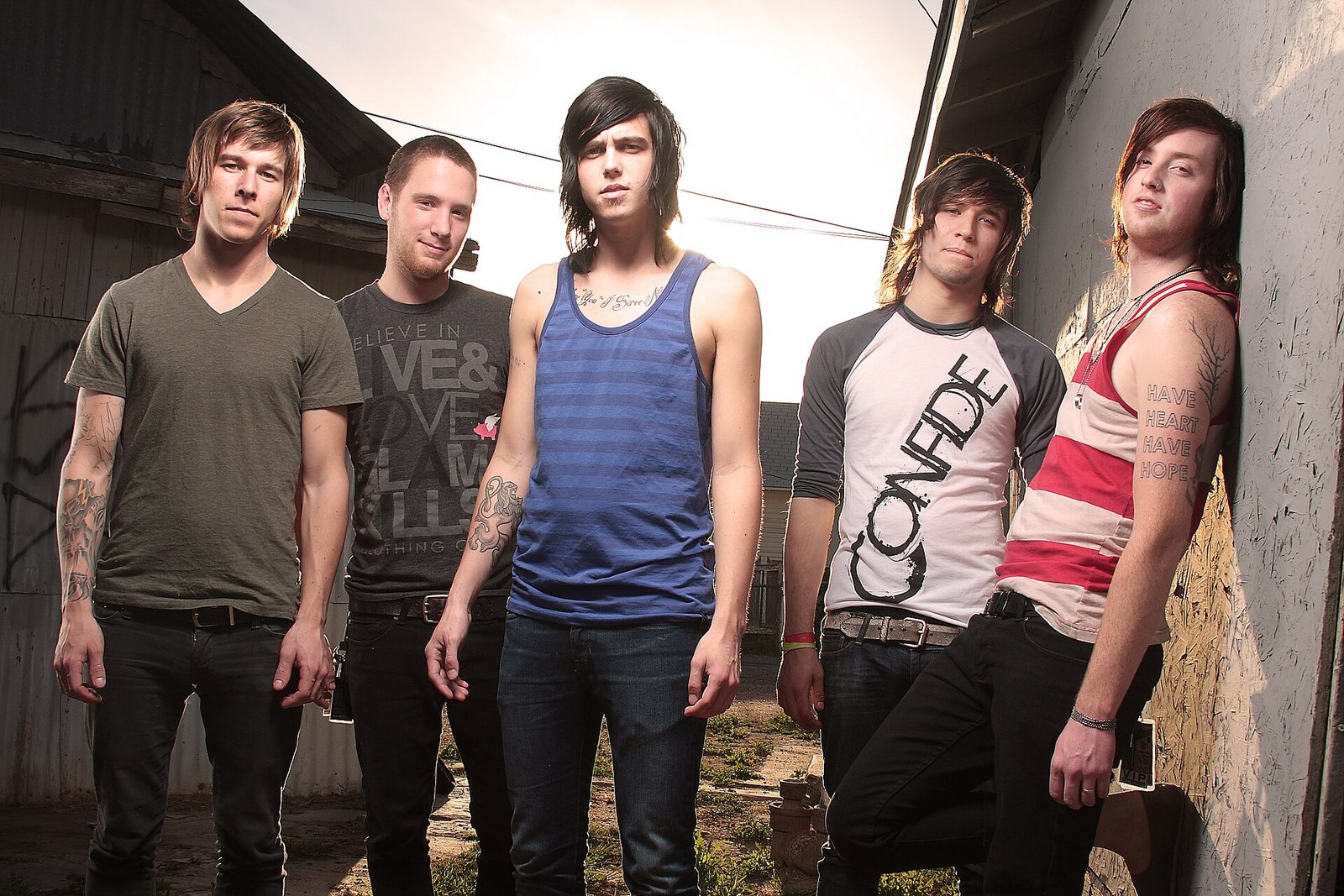 Sleeping With Sirens band portrait outdoors beside a weathered wall, 2010