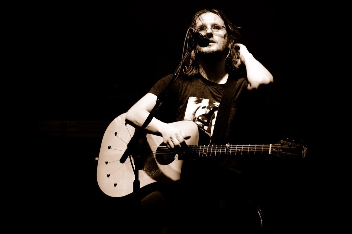 Steven Wilson playing acoustic guitar on stage with Porcupine Tree at Atlantico Live, Rome, 2009