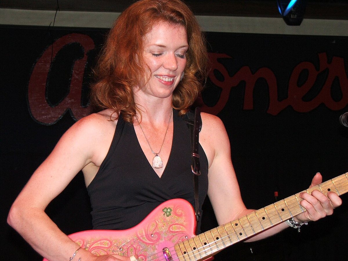 Sue Foley smiling as she plays her pink paisley electric guitar at Antone's, Austin, Texas, 2007