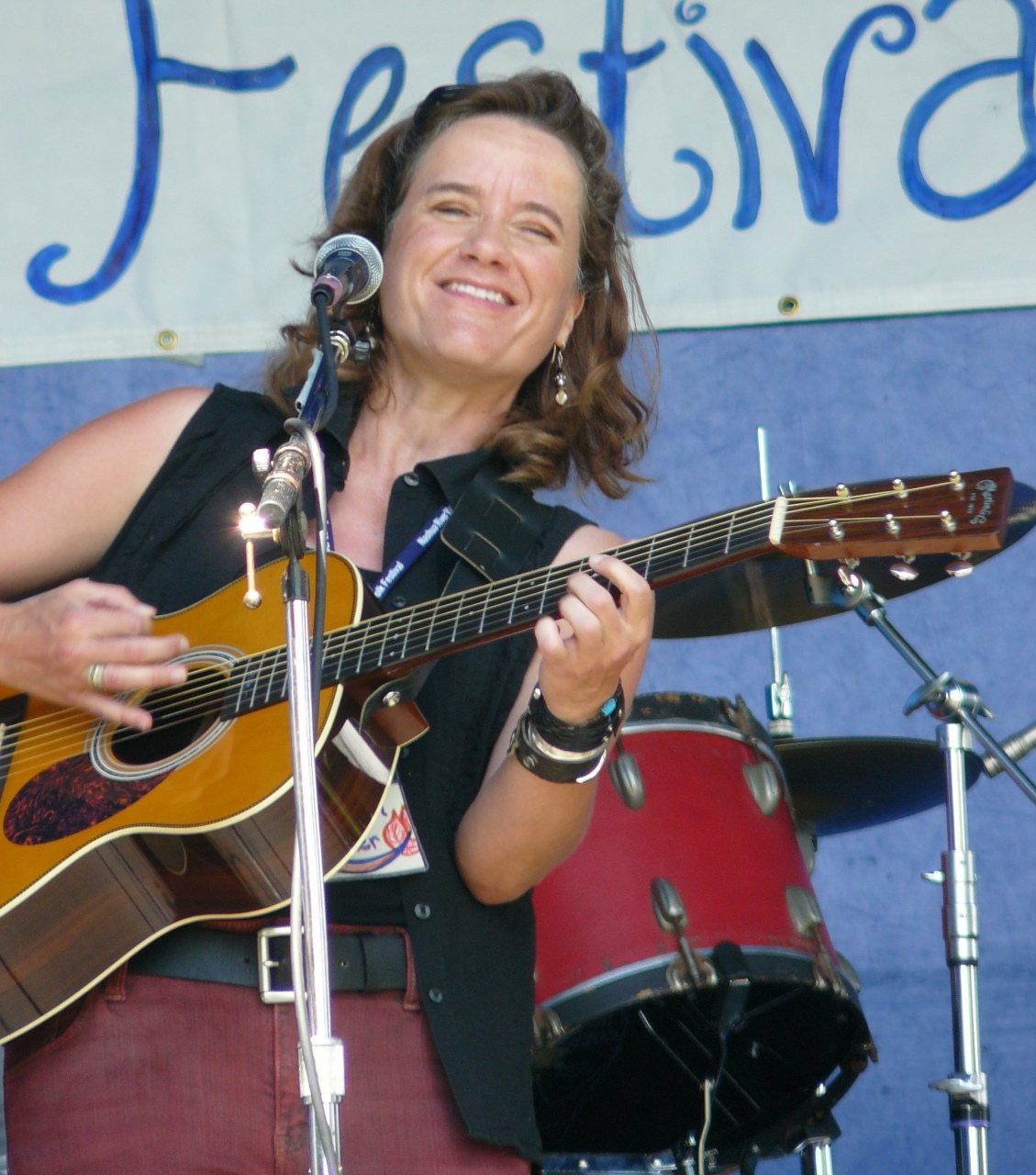 Susan Werner smiling and playing guitar at the Nashua River Valley Folk Festival, Lancaster, Massachusetts, 2008