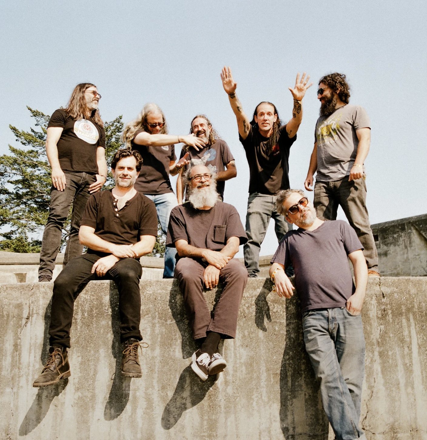 The Budos Band posing on a concrete wall outdoors, 2023