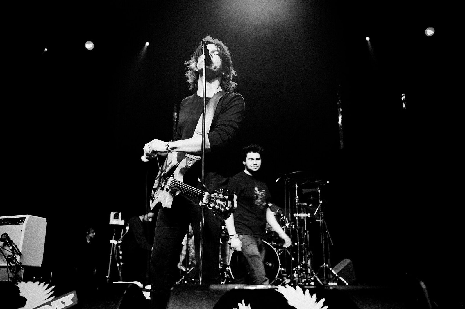 Franz Treichler of The Young Gods singing and playing guitar on stage, 2010