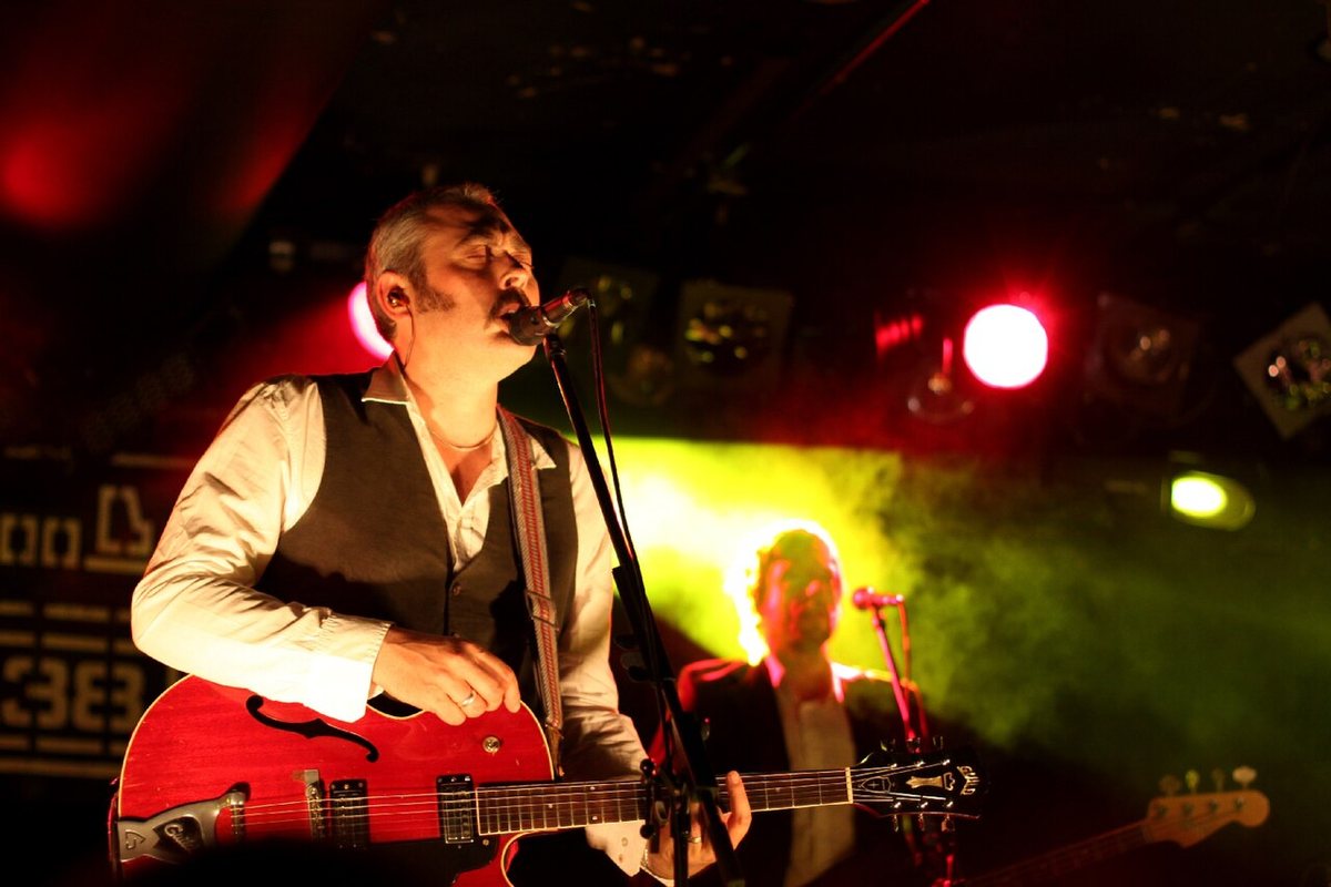 Stuart Staples of Tindersticks singing and playing guitar on stage in Budapest, May 2012