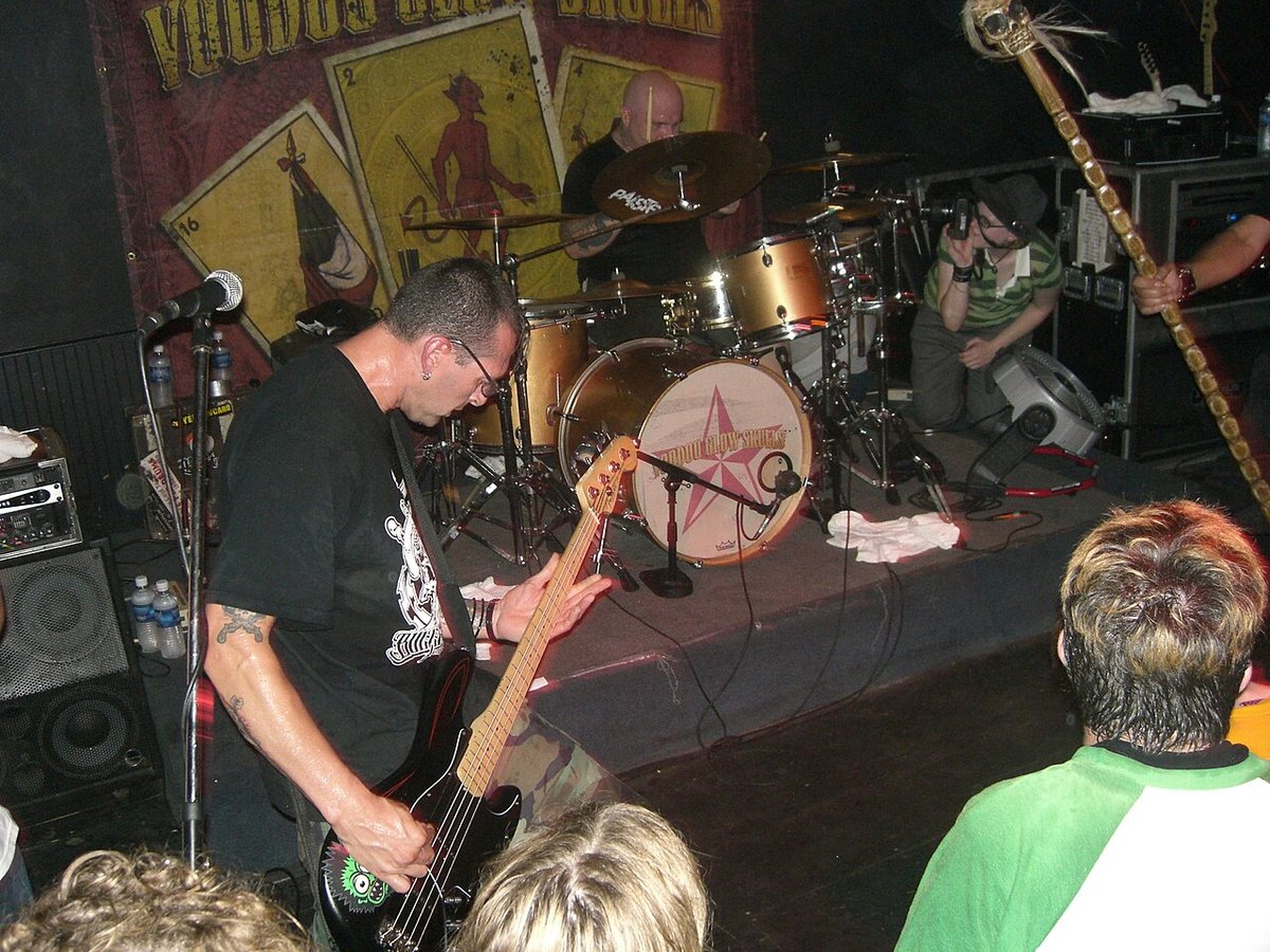 Voodoo Glow Skulls bassist and drummer on stage in front of the band's backdrop, Metairie, Louisiana, 2006