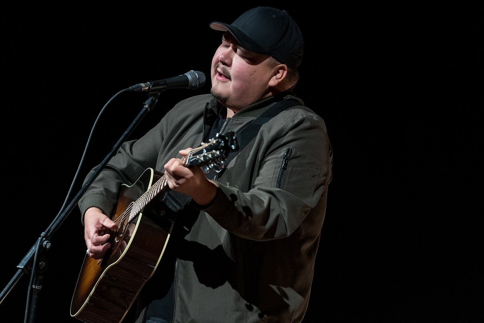 William Prince singing and playing acoustic guitar on stage in 2022