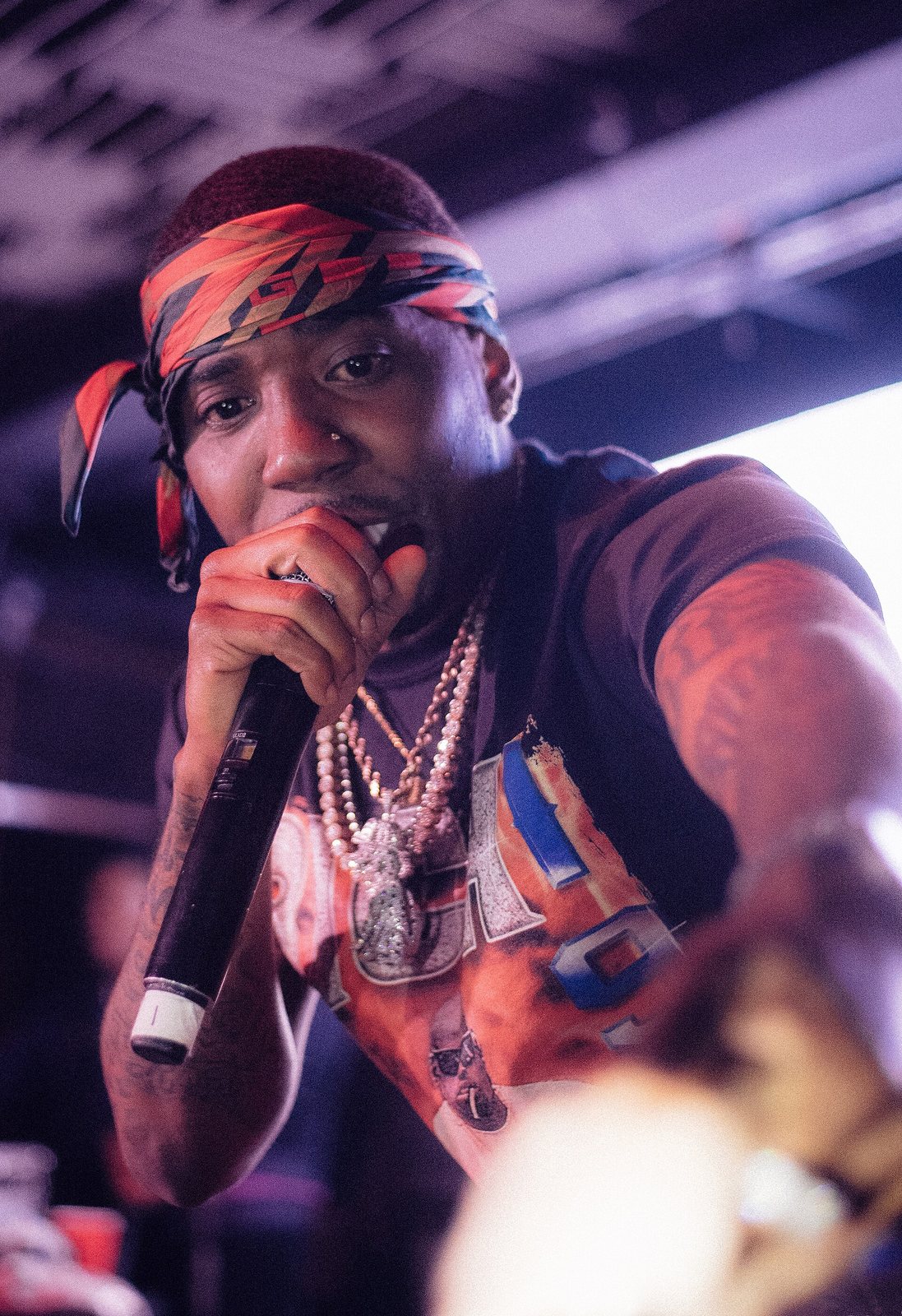 YFN Lucci rapping into a microphone on stage, April 2018