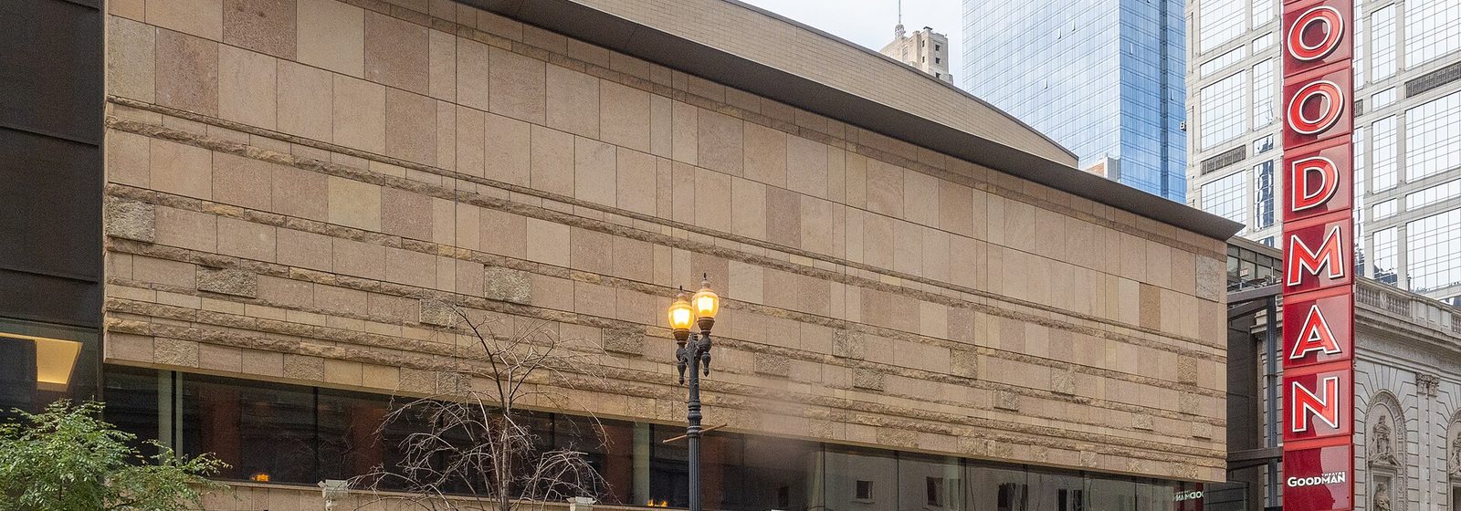 Street-level view of the Goodman Theatre facade with its vertical red Goodman sign on Dearborn Street in downtown Chicago, Illinois - Albert Ivar Goodman Theatre tickets