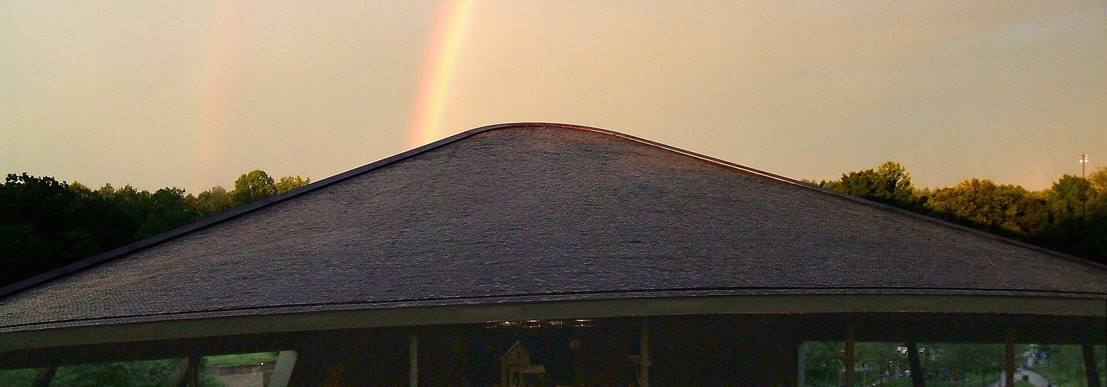 The pavilion of Blossom Music Center in Cuyahoga Falls, Ohio, seen from the lawn with a rainbow overhead - Blossom Music Center tickets