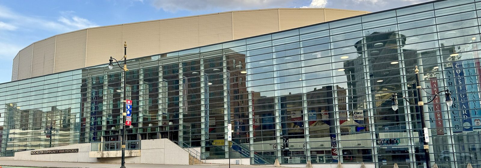 Street-level view of the glass facade of the Blue Cross Arena at the Rochester Community War Memorial in downtown Rochester, New York - Blue Cross Arena tickets