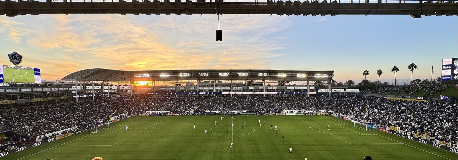 Wide interior view of the seating bowl, canopy roof, and pitch at Dignity Health Sports Park in Carson, California, at sunset during a soccer match - Dignity Health Sports Park - Stadium tickets