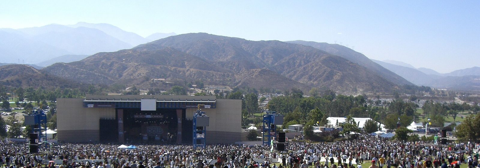 Festival crowd on the lawn facing the covered stage pavilion of Glen Helen Amphitheater (then San Manuel Amphitheater) in San Bernardino, California, with the San Bernardino Mountains behind - Glen Helen Amphitheater tickets
